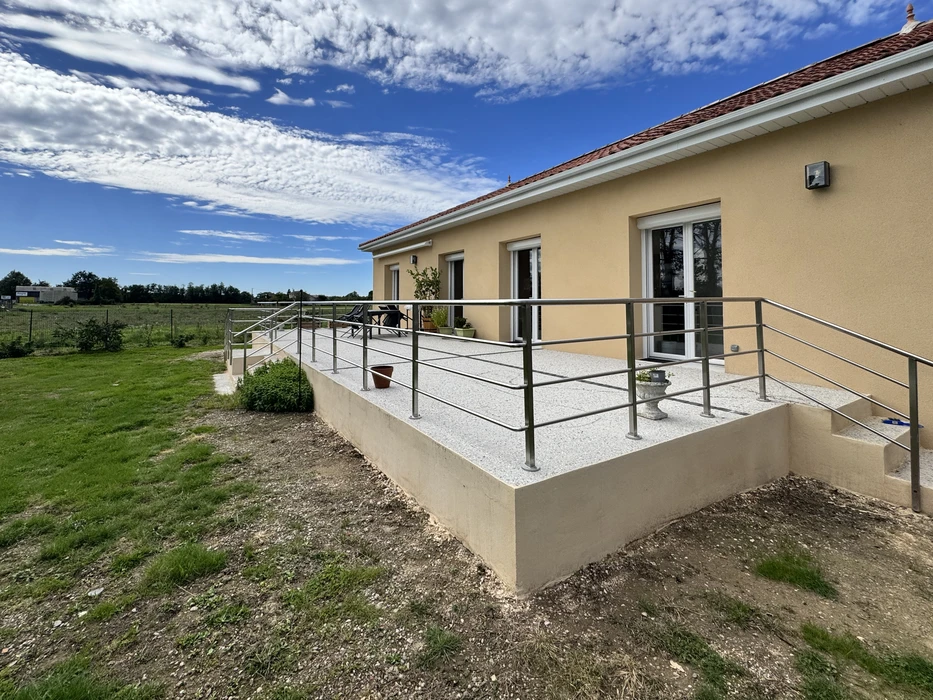 Terrasse surélevée extérieure d'une maison contemporaine avec garde-corps métallique inox à barreaudage horizontal