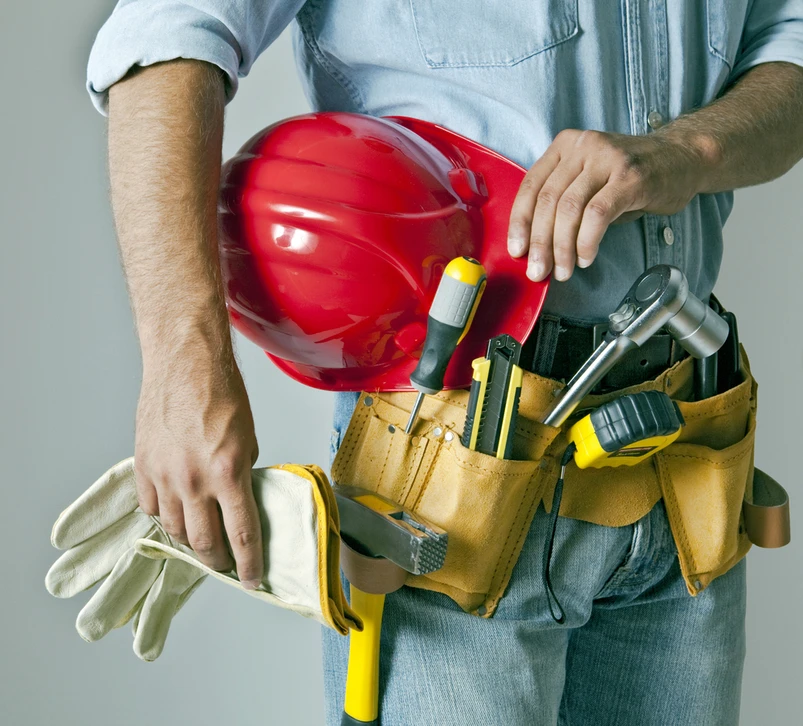 Ouvrier du b&acirc;timent en casque de s&eacute;curit&eacute; jaune consulte une tablette num&eacute;rique sur chantier de construction