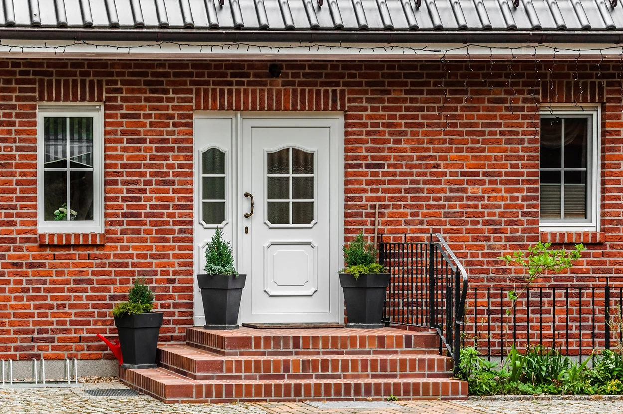 Façade d'immeuble haussmannien parisien en pierre de taille beige avec balcons en fer forgé