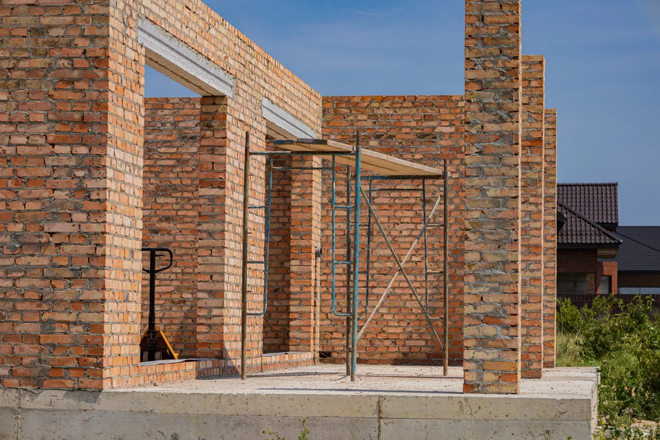 Scène d'intérieur avec trois personnes autour d'une table en bois effectuant une poignée de main lors d'une transaction immobilière