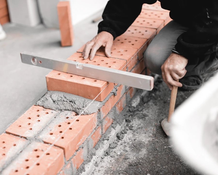 Artisan sculpteur travaillant dans son atelier, utilisant un maillet et un ciseau à bois pour façonner une sculpture figurative en bois naturel